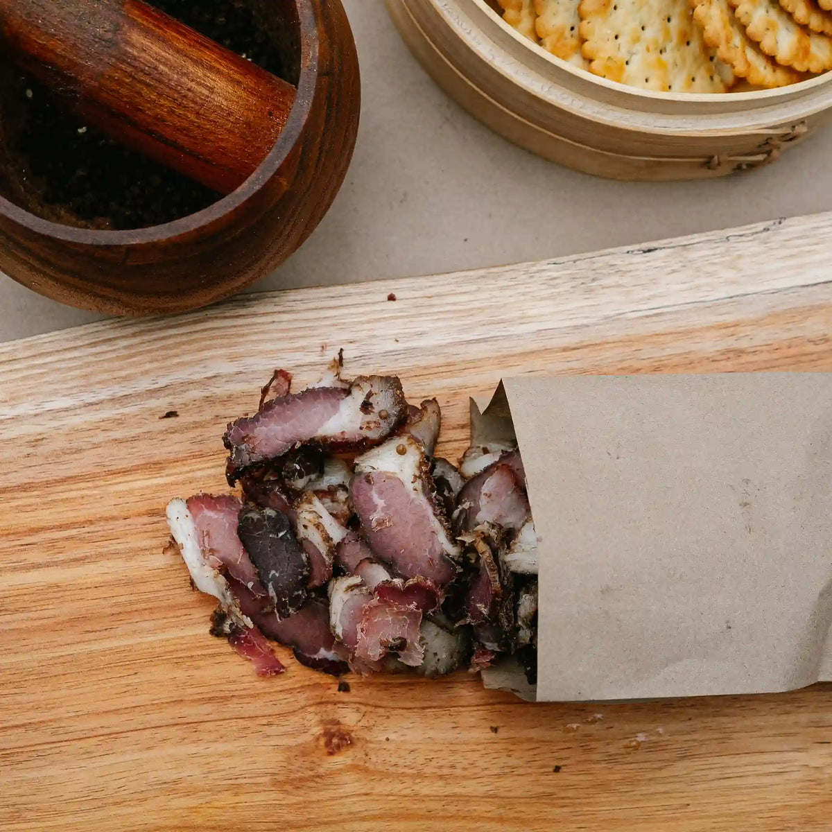 Sliced picanha biltong from Greeff's Butchery, Knysna, on a wooden board.